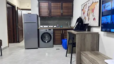 a kitchen with a refrigerator and a washing machine at One bedroom near University of Jordan in Amman