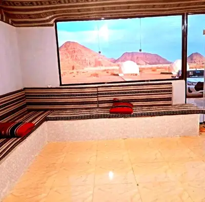 a room with a large window with a view of the desert at Olivia Rum Luxury Bubbles & Jeep Tours in Wadi Rum