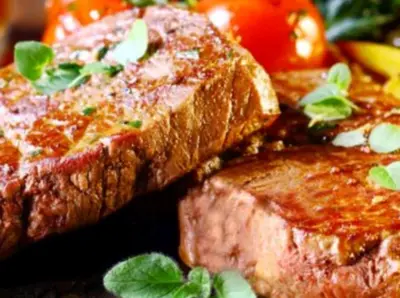 a plate of food with meat and tomatoes on it at Olivia Rum Luxury Bubbles & Jeep Tours in Wadi Rum