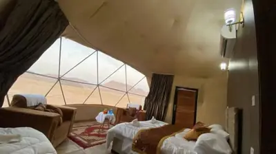 a room with two beds and a large window at Olivia Rum Luxury Bubbles & Jeep Tours in Wadi Rum
