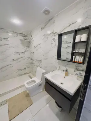 a white bathroom with a toilet and a sink at Olivia Rum Luxury Bubbles & Jeep Tours in Wadi Rum