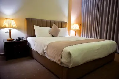 a bed in a hotel room with two lamps on a night stand at 7Wonders by TREND in Petra