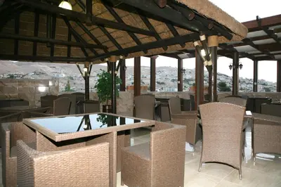 a restaurant with a glass table and wicker chairs at 7Wonders by TREND in Petra
