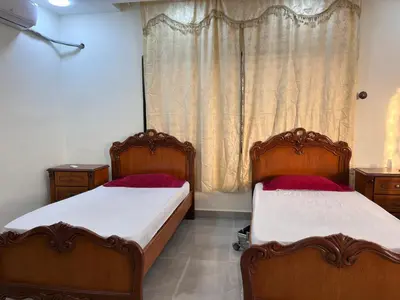 two beds sitting next to each other in a bedroom at \u9f99\u95e8\u5ba2\u6808 in Amman