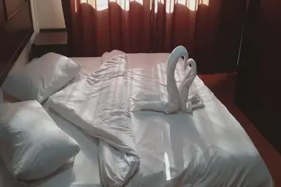 a white bed with a swan made out of pillows at Al-Nujoom Hotel Suites in Amman