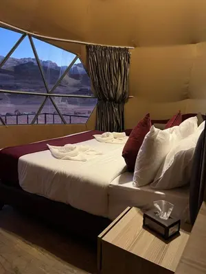 a large bed in a room with a window at HOlIDAY LUXURY WADI RUM in Wadi Rum