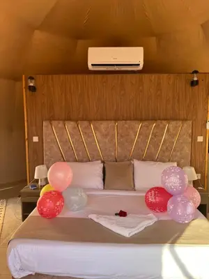 a bed with balloons on it in a room at HOlIDAY LUXURY WADI RUM in Wadi Rum