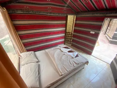 a small bed in a room with a wall at Fig Tree Eco Camp in Disah