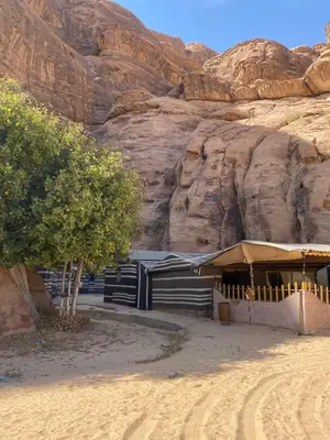 a building in the desert next to a mountain at Fig Tree Eco Camp in Disah