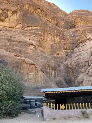 a building in front of a rock wall at Fig Tree Eco Camp in Disah