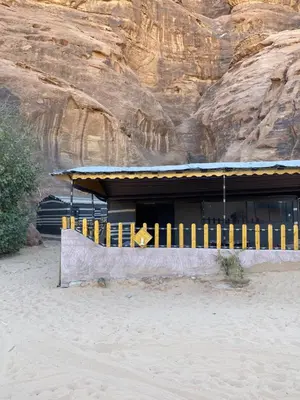 a building on the beach next to a mountain at Fig Tree Eco Camp in Disah