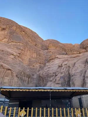 a building in front of a rock wall at Fig Tree Eco Camp in Disah