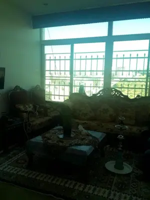 a living room with a couch and a large window at جبيهه in Amman