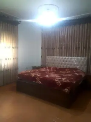 a bedroom with a bed with a red comforter at جبيهه in Amman