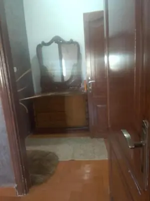 a bathroom with a mirror and a wooden cabinet at جبيهه in Amman