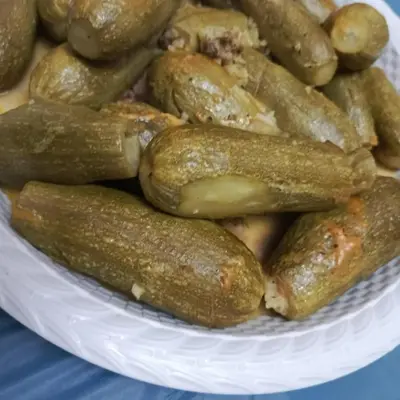 a pile of pickles on a plate on a table at Doven Farm in Wadi Musa