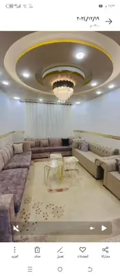 a living room with couches and a chandelier at اربد طريق البترول in Juḩfīyah