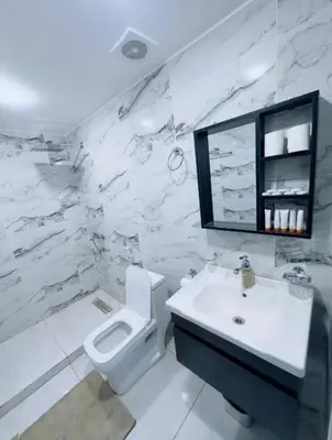 a white bathroom with a toilet and a sink at Rum STAR LUXURY Camp &JEEP Tours in Wadi Rum