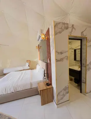 a bedroom with a bed and a mirror and a sink at Rum STAR LUXURY Camp &JEEP Tours in Wadi Rum