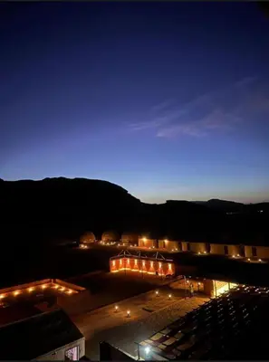 a parking lot lit up at night with lights at Rum STAR LUXURY Camp &JEEP Tours in Wadi Rum