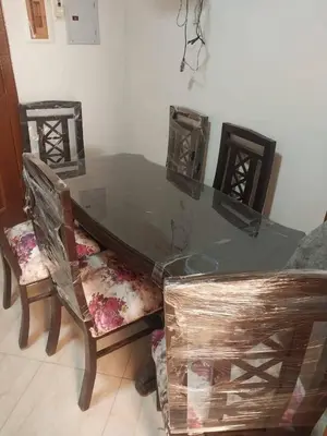 a glass table with two chairs and a table with a glass top at Aqaba Drought inn in Aqaba