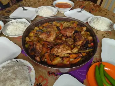 a pan of food on a table with rice at Aqaba Drought inn in Aqaba