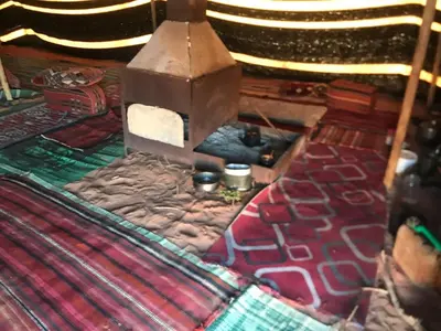 a room with a bed with a stove and a blanket at Bedouin house in Wadi Rum