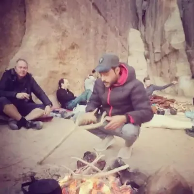 a group of people sitting around a fire at Bedouin house in Wadi Rum