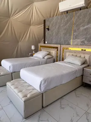 two beds and a couch in a room at The Flowers Camp in Wadi Rum