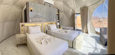 a room with two beds in a tent at The Flowers Camp in Wadi Rum