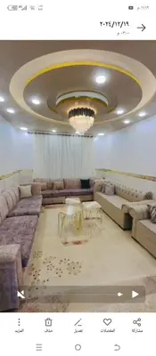 a living room with couches and a chandelier at فيلا اربد طريق البترول in Juḩfīyah
