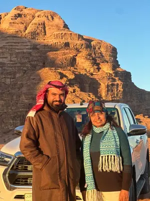 a man and woman standing in front of a mountain at Rum drone tours in Aqaba