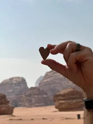 a hand holding a heart in the desert at Rum drone tours in Aqaba