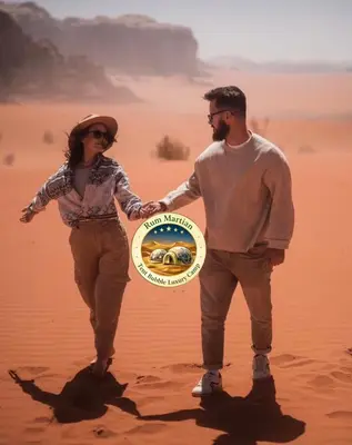 a man and a woman in the desert holding a frisbee at RUM MARTIAN TENT BUBBLES lUXURY CAMP in Wadi Rum