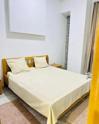 a bedroom with a large bed with white sheets at Loard House in Az Zarqa