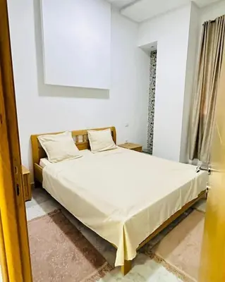 a bedroom with a large bed with white sheets at Loard House in Az Zarqa