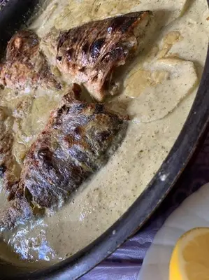 a pan of food with two pieces of meat at Board apartment in Irbid