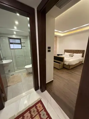 a bathroom with a bedroom with a bed and a tub at 3bedroom apart Deir Ghbar JRE in Amman