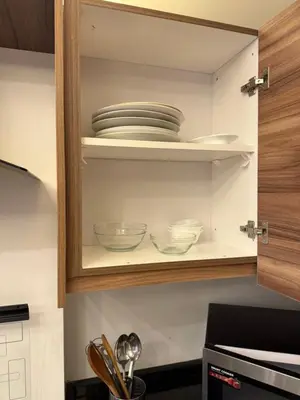 a cupboard with plates and bowls in it at 3bedroom apart Deir Ghbar JRE in Amman