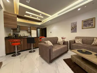 a living room with two couches and a kitchen at 3bedroom apart Deir Ghbar JRE in Amman