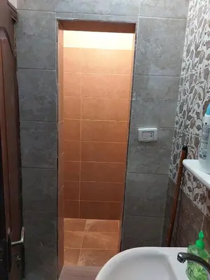 a shower with a glass door in a bathroom at Nice comfy room in Amman
