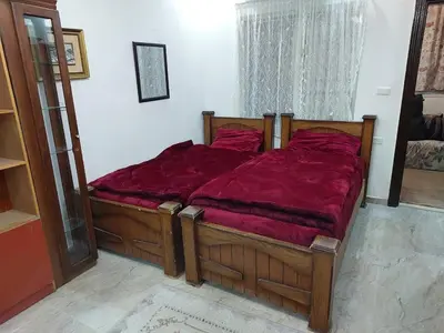 a bedroom with a large bed with a red comforter at Nice comfy room in Amman