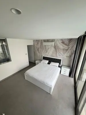 a white bedroom with a bed and a wall at Eva chalet in Deadsea in Al Kafrayn