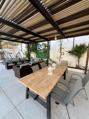 a wooden table and chairs on a patio at Eva chalet in Deadsea in Al Kafrayn