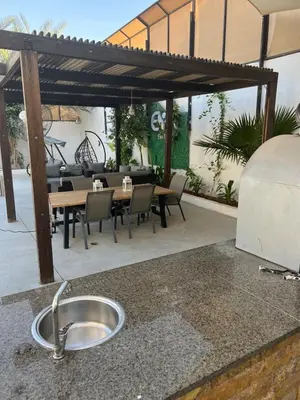 an outdoor kitchen with a sink and a table and chairs at Eva chalet in Deadsea in Al Kafrayn