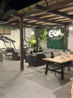a patio with couches and a table and chairs at Eva chalet in Deadsea in Al Kafrayn