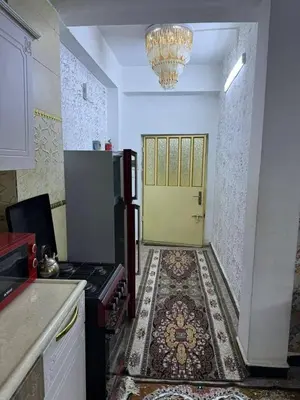 a kitchen with a stove and a yellow door at Rawabi INN in Maţār al Malik Ḩusayn