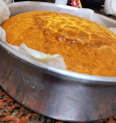 a cake in a pan on a table at Rawabi INN in Maţār al Malik Ḩusayn