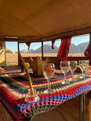 a table with wine glasses on top of it at Rose Al Ghaith Camp in Disah