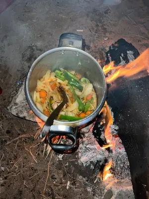 a pot of food is cooking over a fire at The heartbeat of the desert and the stars in Wadi Rum